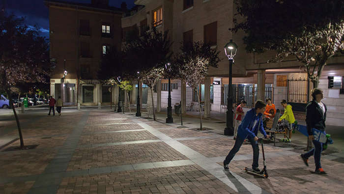 Дети играют на ночной площади, освещенной световыми решениями Philips